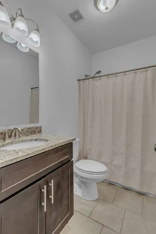 a bathroom with a granite countertop sink a toilet and a mirror