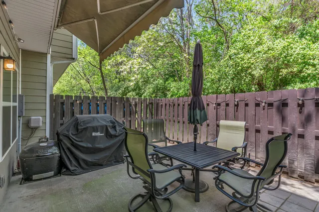 a backyard of a house with barbeque oven table and chairs