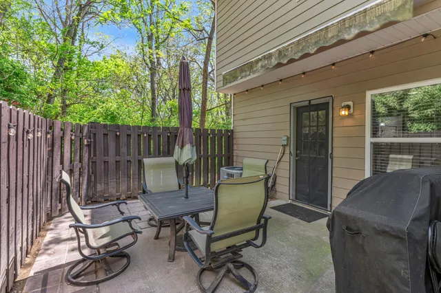 a view of a chairs and table in the back yard of the house