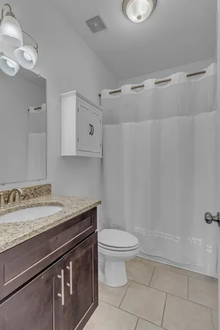 a bathroom with a granite countertop sink toilet and shower