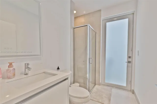 a kitchen with stainless steel appliances kitchen island granite countertop a table a stove a refrigerator and a view of living room with a large window