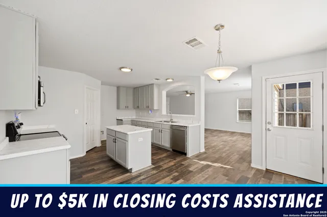 a open kitchen with white cabinets and granite counter tops