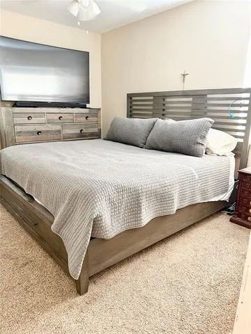a bedroom with bed and a flat screen tv