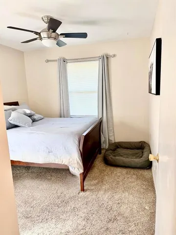 a bedroom with a bed and a ceiling fan