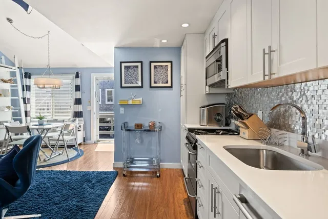 a kitchen with stainless steel appliances a sink a stove top oven a counter space and cabinets