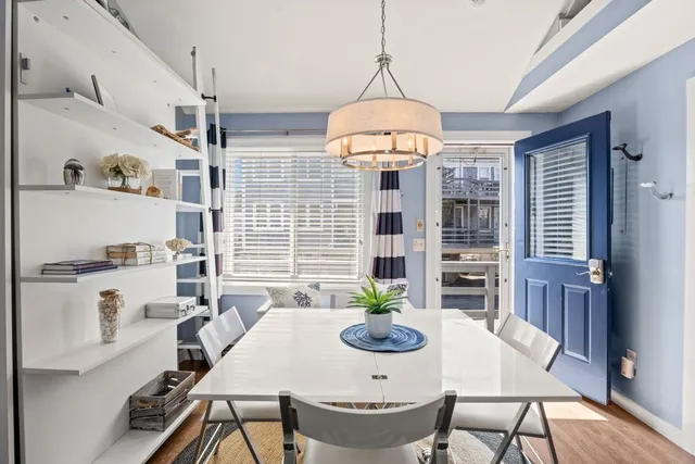 a view of a dining room with furniture a chandelier and wooden floor