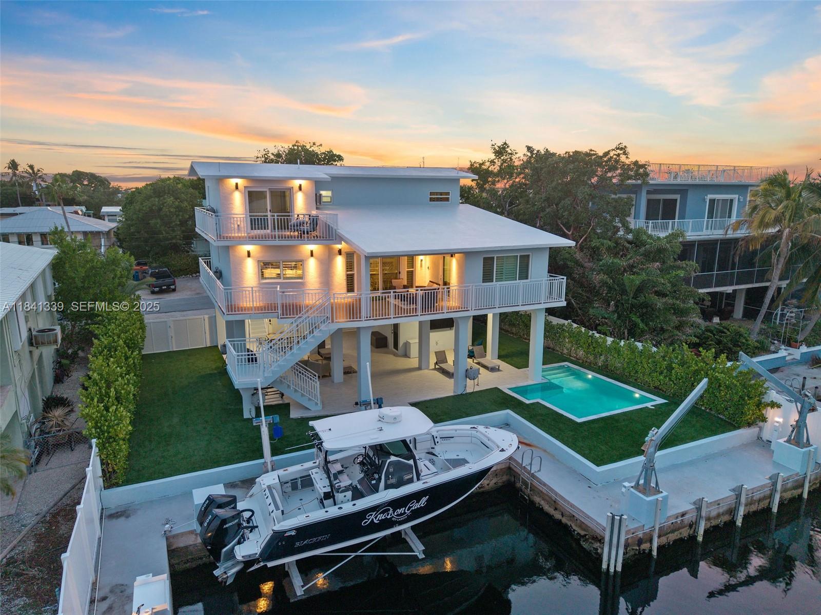 an aerial view of a house with swimming pool garden and patio