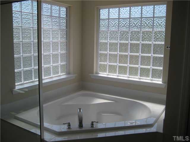 229 Forbes Road, Unit LOT62 Wake Forest, NC 27587 - Photo 7 of 12 Master bath features an oversize soaking tub with two large faux glass block windows for lots of light while preserving your privacy. Tile floors, double vanities and a seperate water closet as well.
