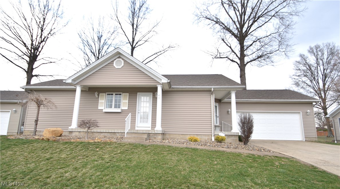 Single story home with concrete driveway, a garage, and a front yard