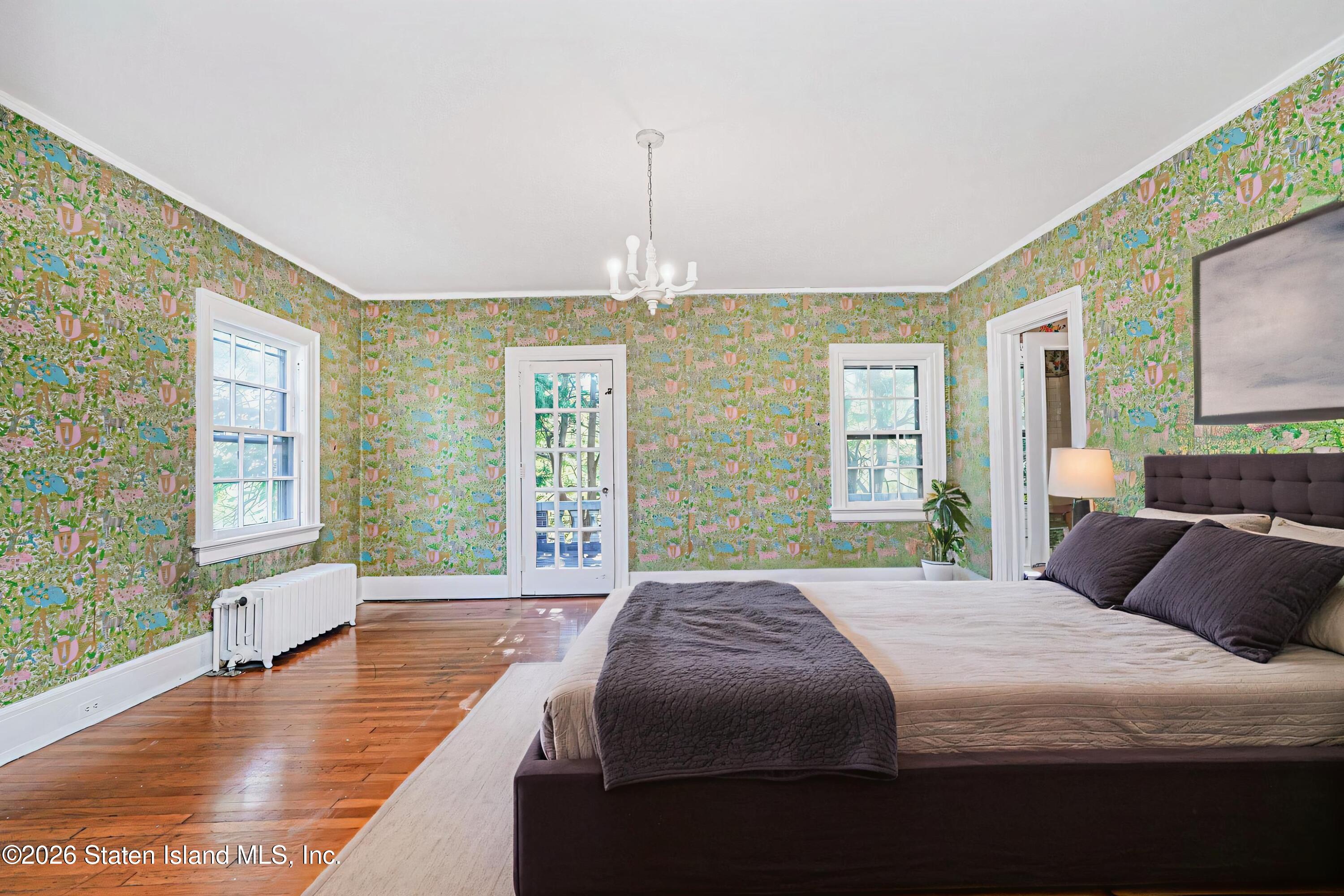 12 Silver Lake Road Staten Island, NY 10301 - Photo 16 of 33 a bedroom with a balcony a bed and a chandelier