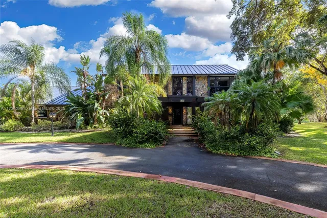 a front view of a house with a yard and shrubs