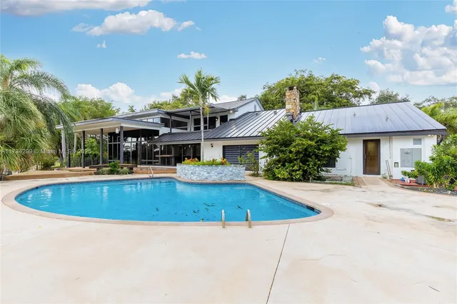 a view of a house with pool and a yard