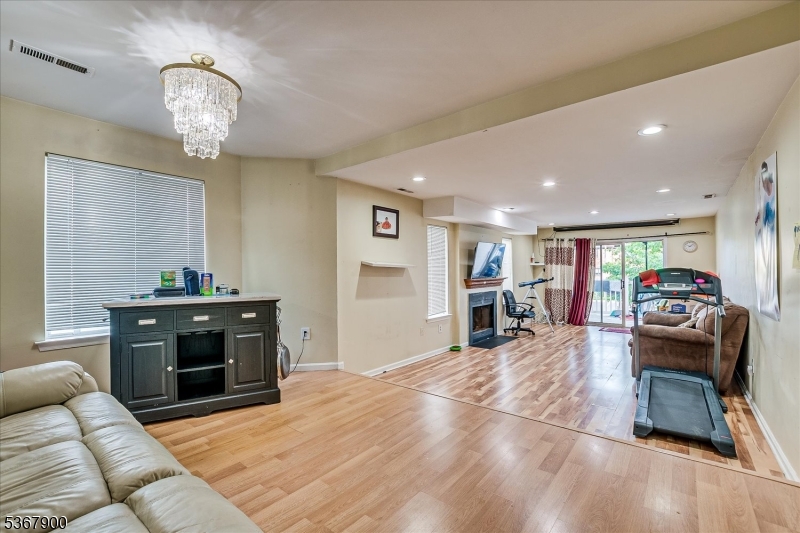 1702 Amanda Court, Unit 1702 Piscataway, NJ 08854 - Photo 1 of 11 a living room with furniture a fireplace and a chandelier