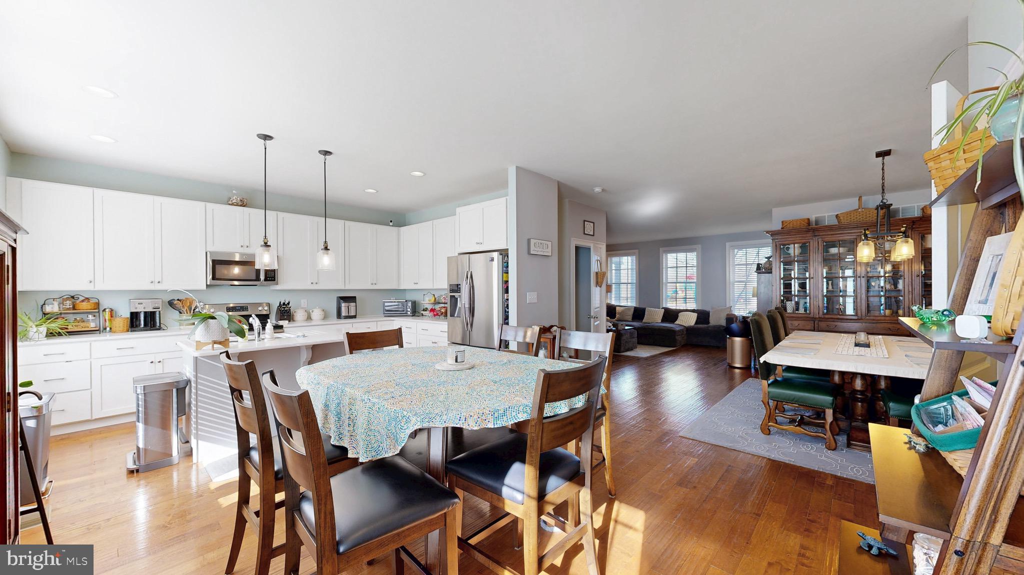 819 Mapleton Avenue Middletown, DE 19709 - Photo 6 of 56 a view of a dining room and livingroom with furniture wooden floor a rug a painting and a chandelier