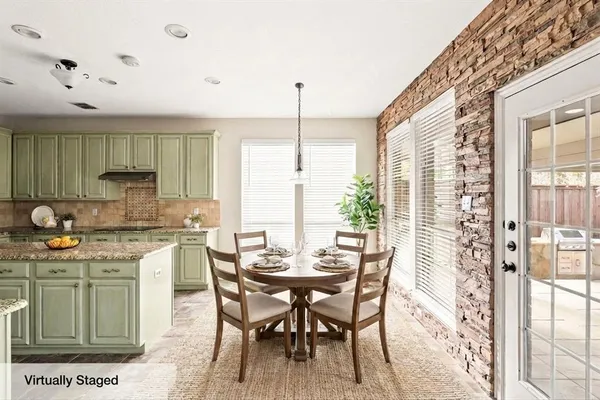 a kitchen with stainless steel appliances kitchen island granite countertop a table and chairs in it