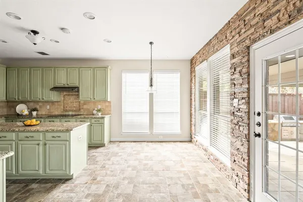 a large kitchen with kitchen island granite countertop a stove a sink and a refrigerator