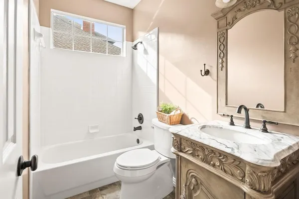 a bathroom with a granite countertop sink a toilet and shower