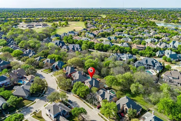an aerial view of residential houses with outdoor space and trees