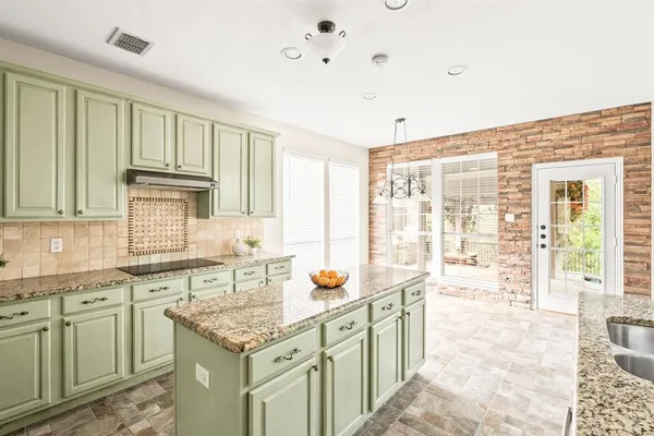 a kitchen that has a lot of cabinets in it and wooden floor