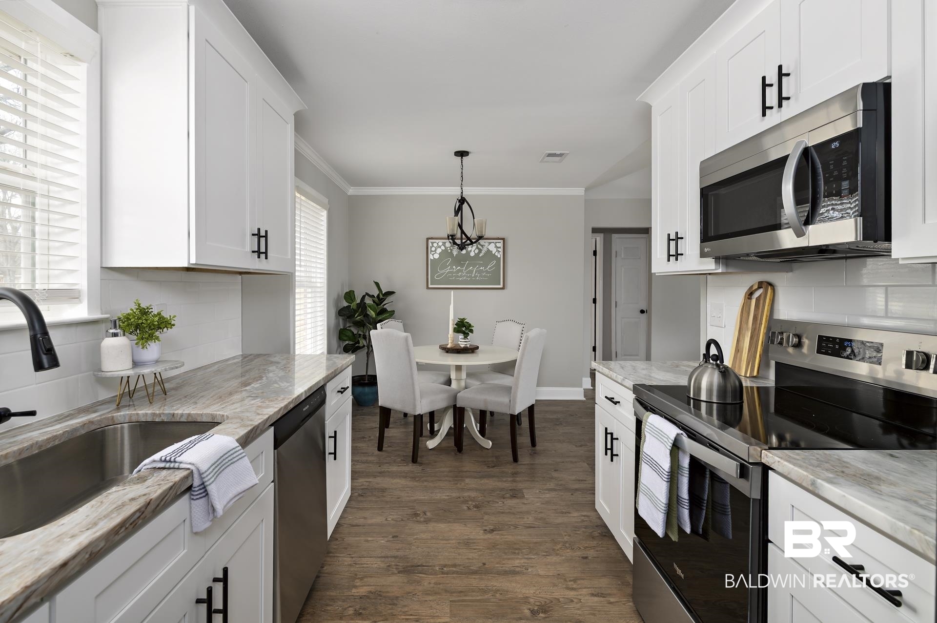 21717 Shadowbrook Street Robertsdale, AL 36567 - Photo 20 of 32 Kitchen with stainless steel appliances, a sink, white cabinetry, dark wood-style floors, and crown molding