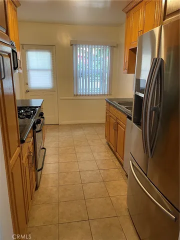a kitchen with granite countertop a refrigerator a stove a sink and dishwasher