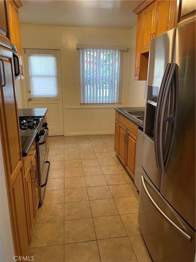 5901 Woodman Valley, Unit 5901 Valley Glen, CA 91401 - Photo 3 of 8 a kitchen with granite countertop a refrigerator a stove a sink and dishwasher