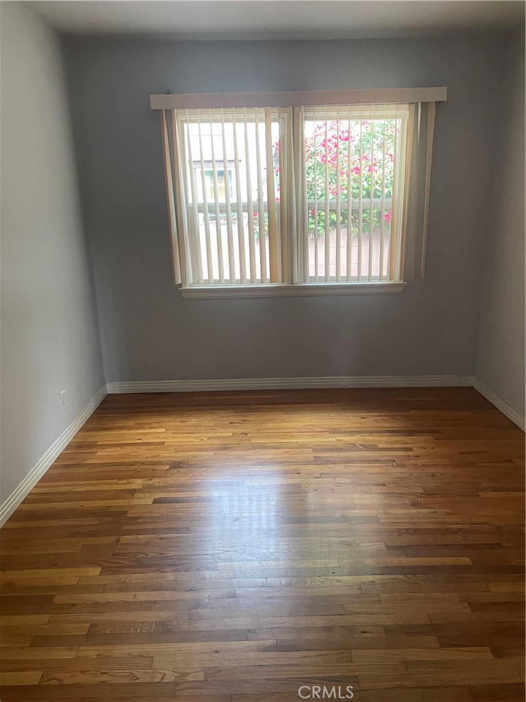 5901 Woodman Valley, Unit 5901 Valley Glen, CA 91401 - Photo 5 of 8 a view of an empty room with wooden floor and a window