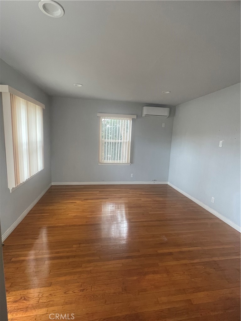5901 Woodman Valley, Unit 5901 Valley Glen, CA 91401 - Photo 6 of 8 an empty room with wooden floor and windows
