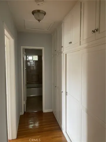 a view of a hallway with wooden floor and closet