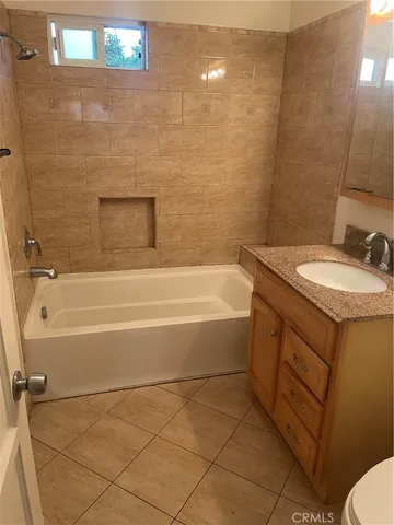 a bathroom with a granite countertop sink a toilet and bathtub
