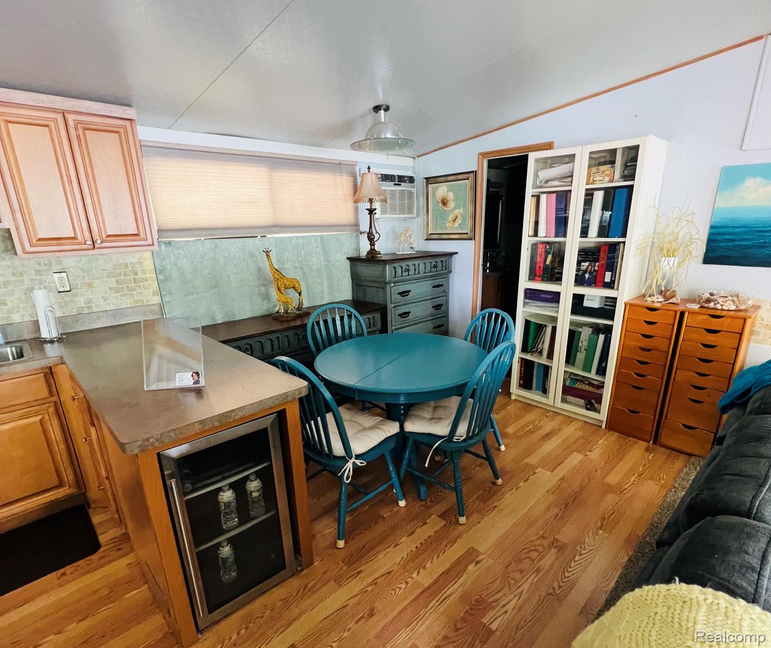 10001 Goodall Road, Unit 404 Durand, MI 48429 - Photo 20 of 50 Dining space with light wood-style floors, wine cooler, and vaulted ceiling