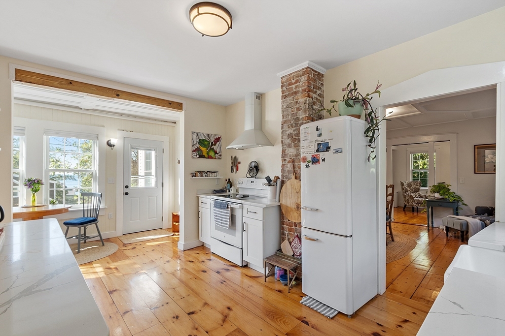 1101 Washington Street, Unit WINTER Gloucester, MA 01930 - Photo 14 of 41 a kitchen with a refrigerator a stove top oven a dining table and chairs