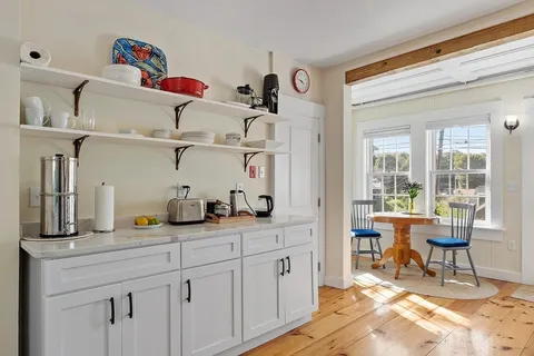 a kitchen with cabinets and chairs in it