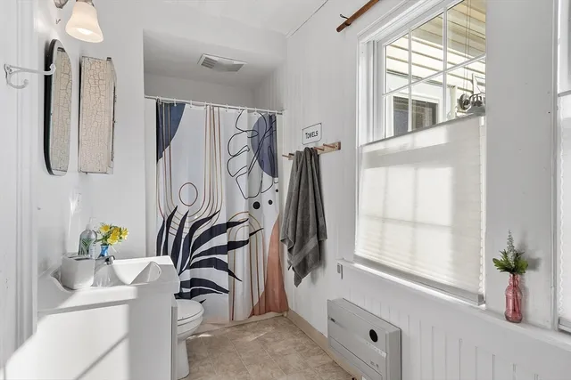 a bathroom with a sink a bathtub and a window