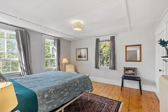 a bedroom with a bed and a table in it next to a window