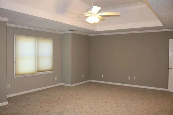 an empty room with a window and a fan