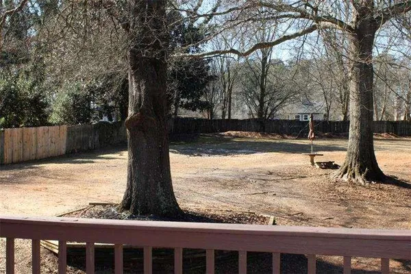 a view of a yard with wooden fence