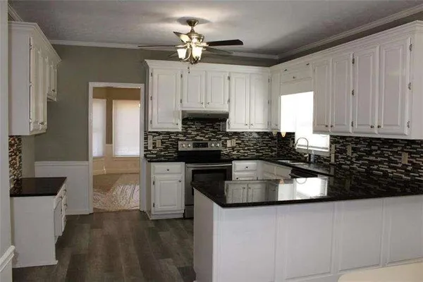 a kitchen with granite countertop a sink stainless steel appliances and cabinets