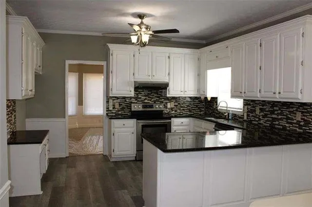 a kitchen with granite countertop a sink stainless steel appliances and cabinets