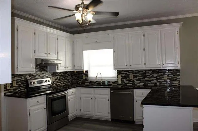 a kitchen with granite countertop white cabinets and black appliances