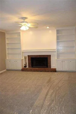 a view of empty room with wooden floor and fireplace