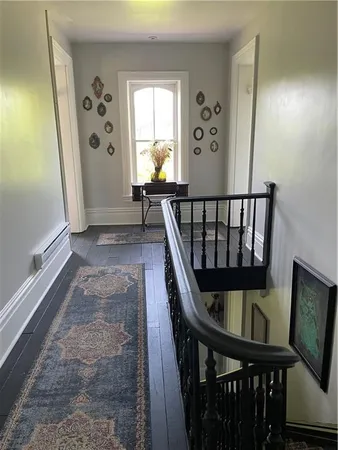 a view of a hallway with wooden floor and stairs