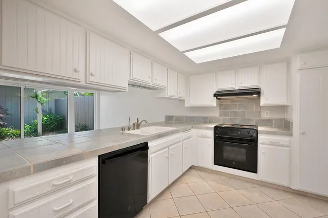 a kitchen with granite countertop a stove a sink and a microwave