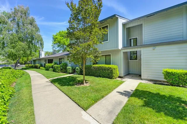 a front view of a house with a yard and trees