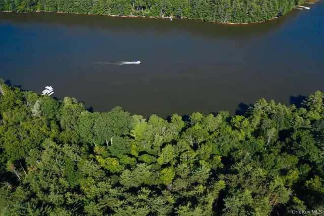 an aerial view of a house with a yard and lake view