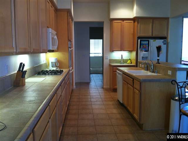 10735 Ivy Gate Court Reno, NV 89521 - Photo 4 of 12 a kitchen with stainless steel appliances granite countertop a stove a sink and a microwave