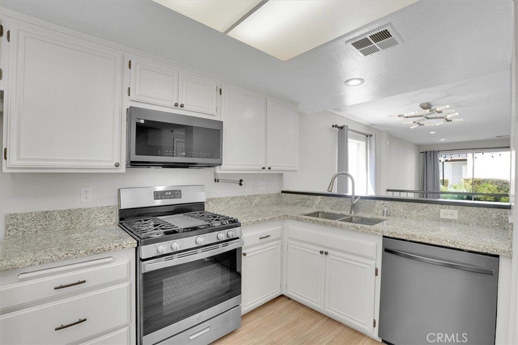 5610 Las Virgenes Road, Unit 50 Calabasas, CA 91302 - Photo 17 of 40 a kitchen with granite countertop cabinets stainless steel appliances and a counter space