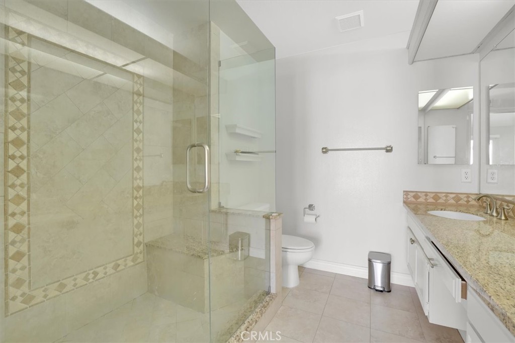 5610 Las Virgenes Road, Unit 50 Calabasas, CA 91302 - Photo 27 of 40 a bathroom with a granite countertop sink a toilet and shower