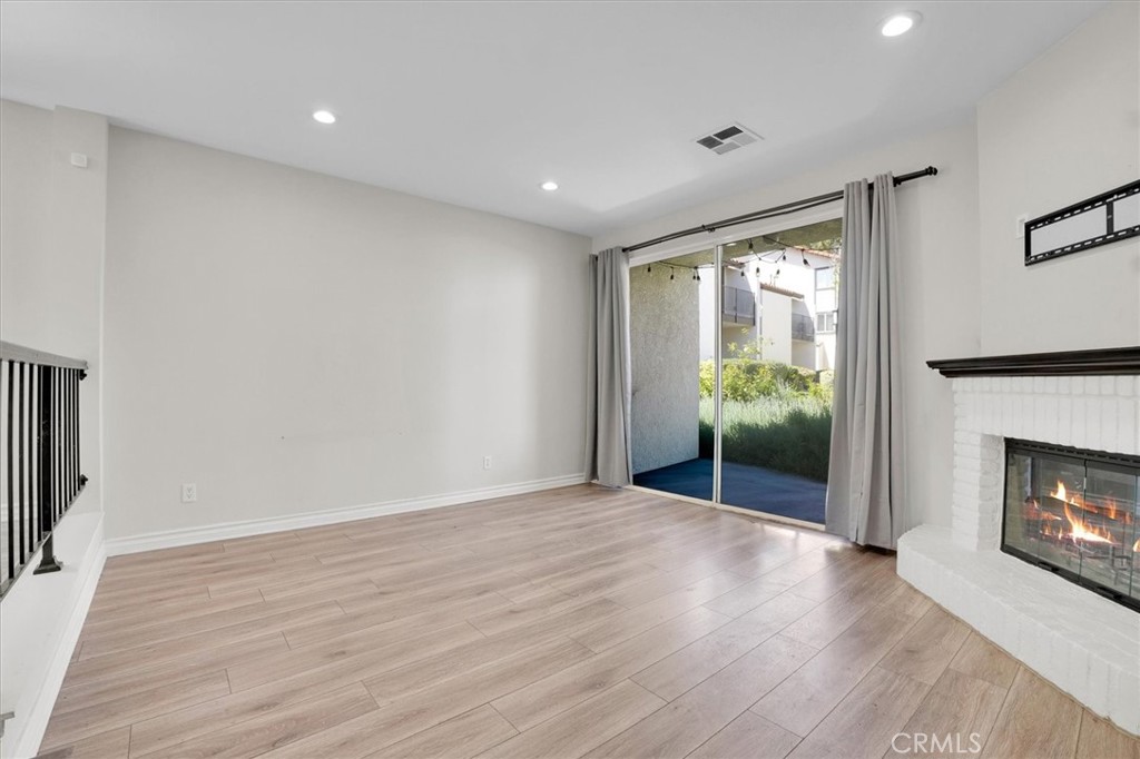 5610 Las Virgenes Road, Unit 50 Calabasas, CA 91302 - Photo 4 of 40 a view of an empty room with wooden floor fireplace and a window