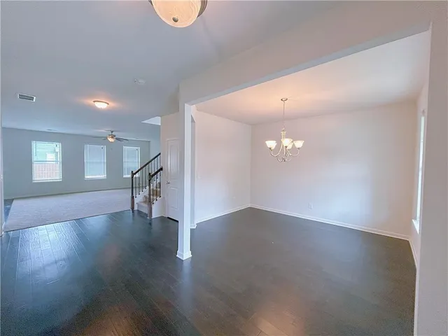 a view of a big room with wooden floor staircase and a kitchen
